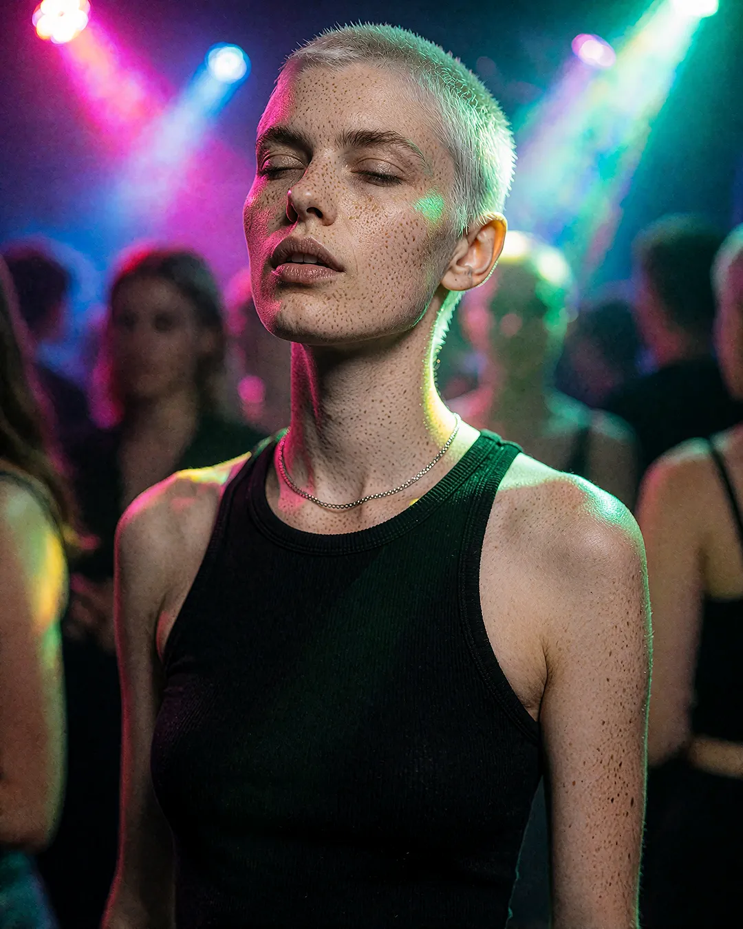 Robin Aschenberg tanzt mit geschlossenen Augen im Lichterrausch eines Clubs, Avantgarde-Editorial.