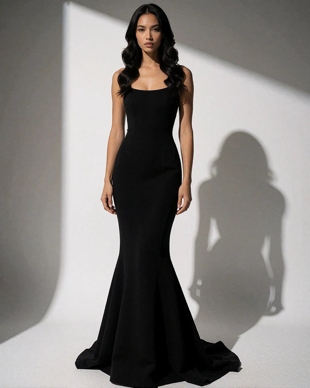 Mika Thornbury trägt ein schwarzes Meerjungfrau-Kleid mit eckigem Ausschnitt im Fotostudio.