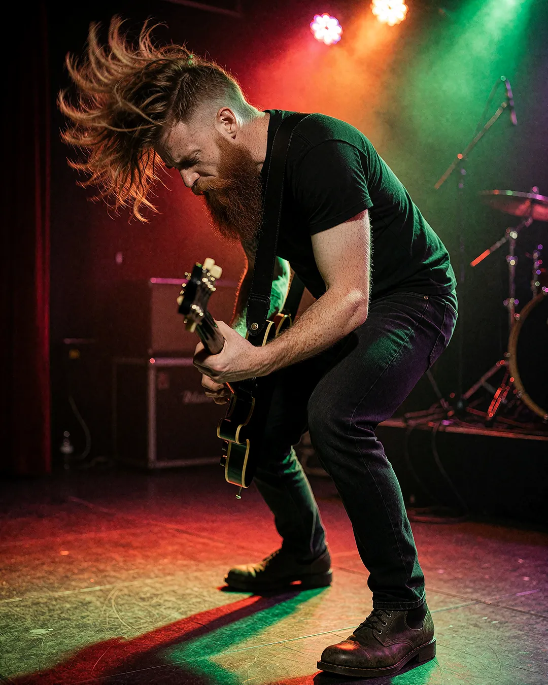 Ronan Flaherty headbangt mit E-Gitarre auf der Clubbühne im bunten Scheinwerferlicht.