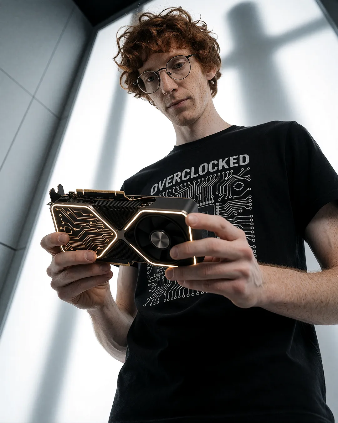 Tobias Osterhage betrachtet konzentriert eine Grafikkarte im Overclocked-T-Shirt.